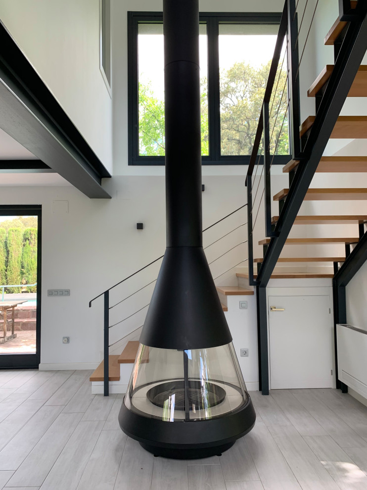 Modelo de comedor de cocina minimalista grande con paredes blancas, suelo de baldosas de porcelana, todas las chimeneas y suelo marrón