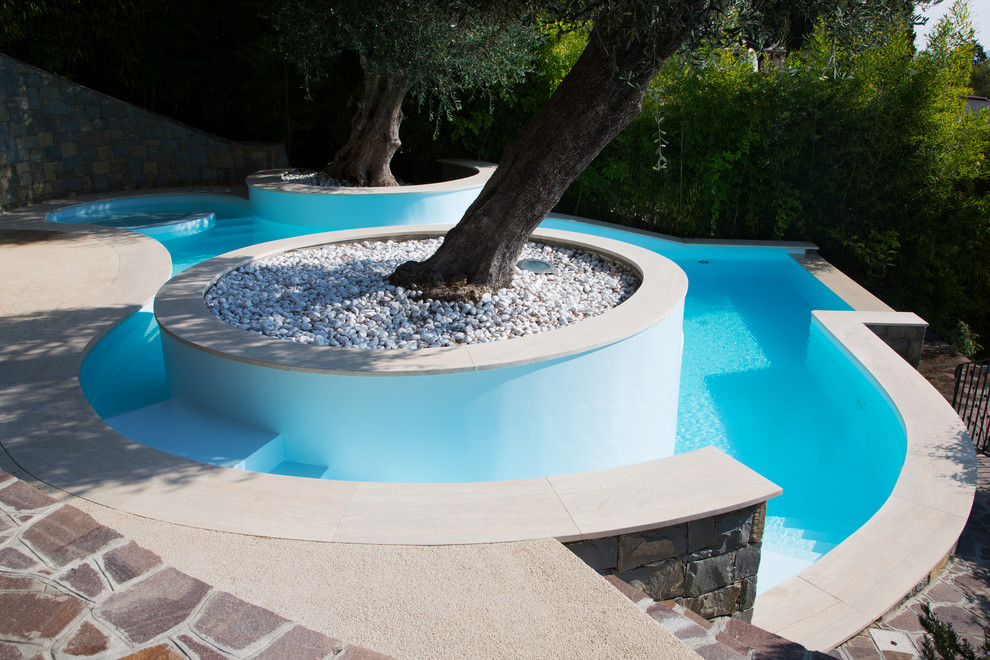 Design ideas for a mid-sized mediterranean backyard custom-shaped infinity pool in Other.