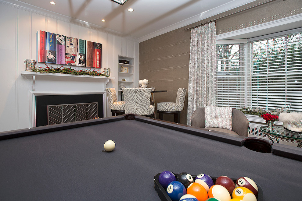 Photo of a mid-sized contemporary family room in New York with a game room, beige walls and a standard fireplace.