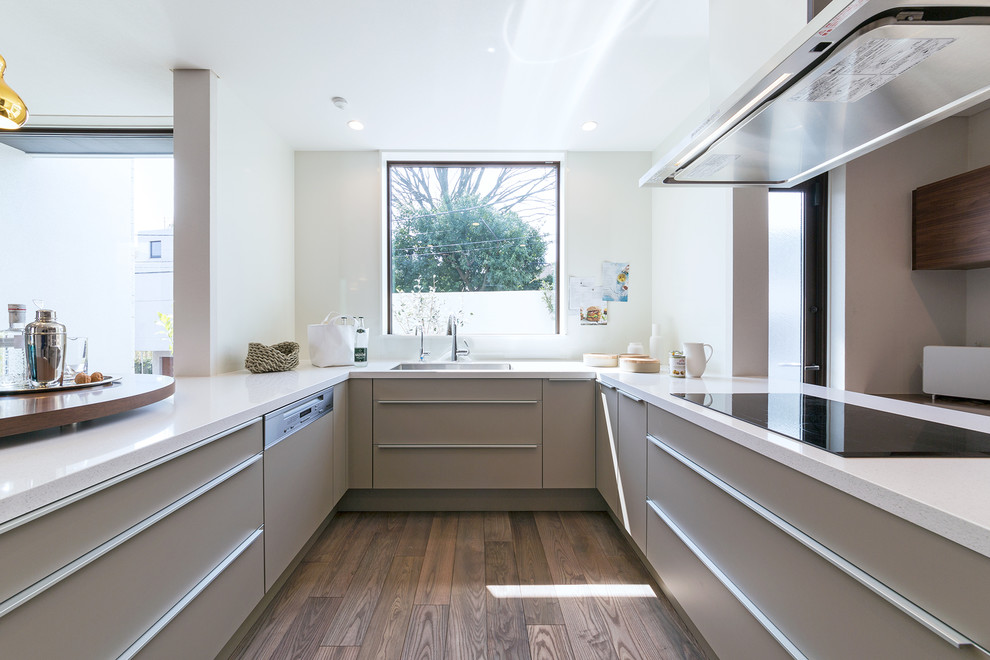 This is an example of a large contemporary u-shaped kitchen in Tokyo with an undermount sink, flat-panel cabinets, beige cabinets and a peninsula.