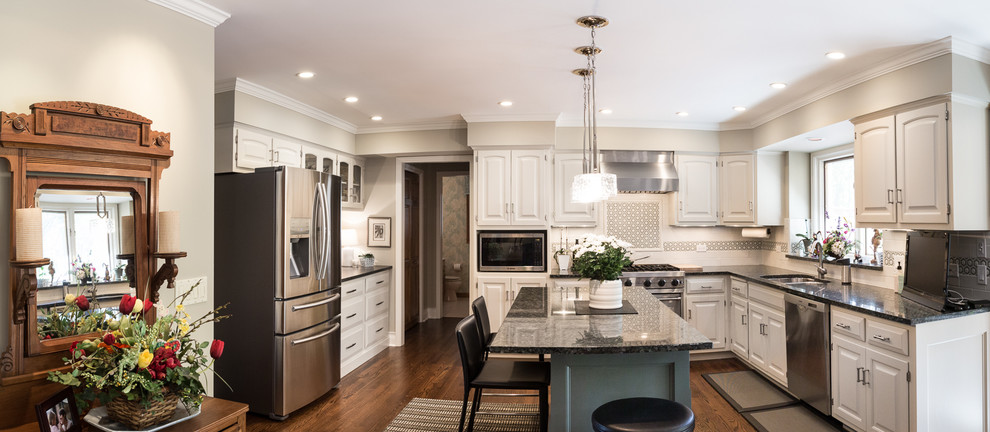 Eat-in kitchen - large transitional u-shaped brown floor and dark wood floor eat-in kitchen idea in Chicago with an undermount sink, raised-panel cabinets, white cabinets, granite countertops, white backsplash, stainless steel appliances, an island and subway tile backsplash