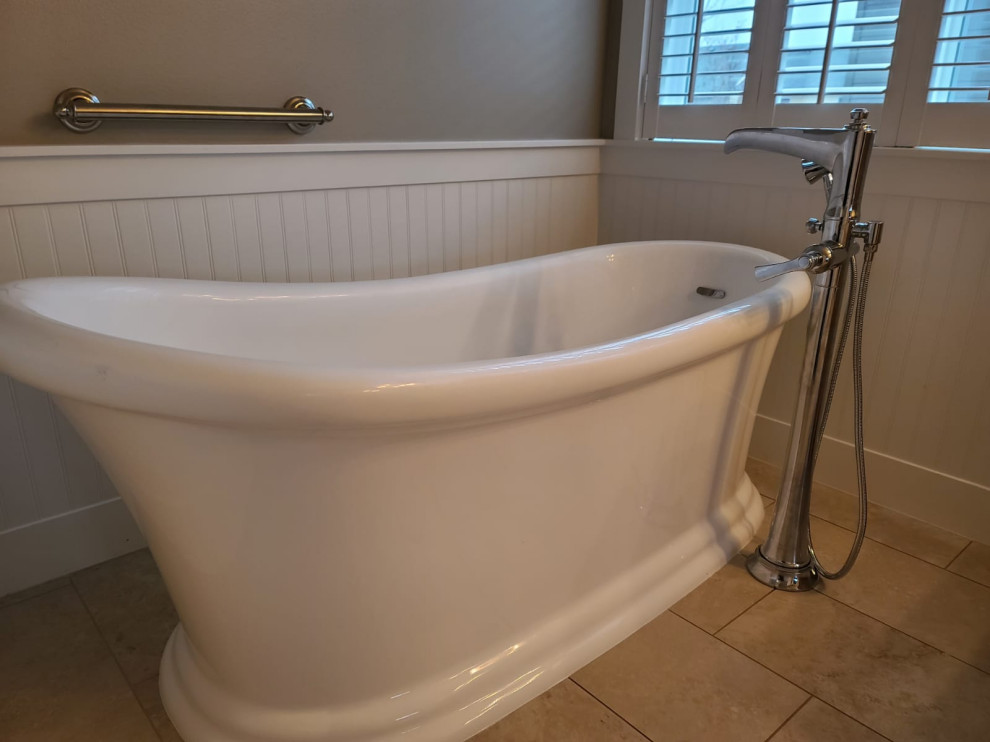 Design ideas for a mid-sized country master bathroom in Portland with medium wood cabinets, a freestanding tub, a one-piece toilet, beige walls, porcelain floors, a drop-in sink, tile benchtops, beige floor, an enclosed toilet, a double vanity, a built-in vanity and decorative wall panelling.