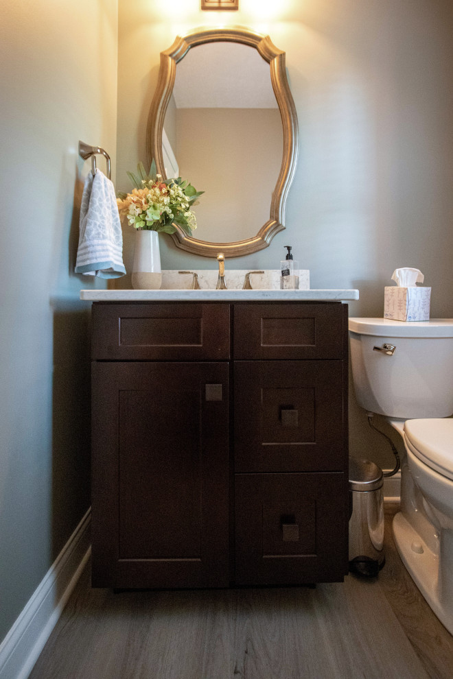 Example of a small transitional vinyl floor and beige floor powder room design in Cleveland with flat-panel cabinets, brown cabinets, a two-piece toilet, beige walls, an undermount sink, quartz countertops, beige countertops and a built-in vanity