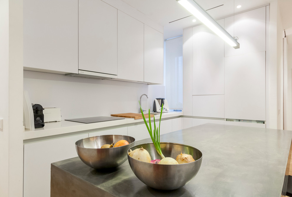 Design ideas for a mid-sized contemporary l-shaped open plan kitchen in Madrid with a single-bowl sink, flat-panel cabinets, white cabinets, white appliances and with island.