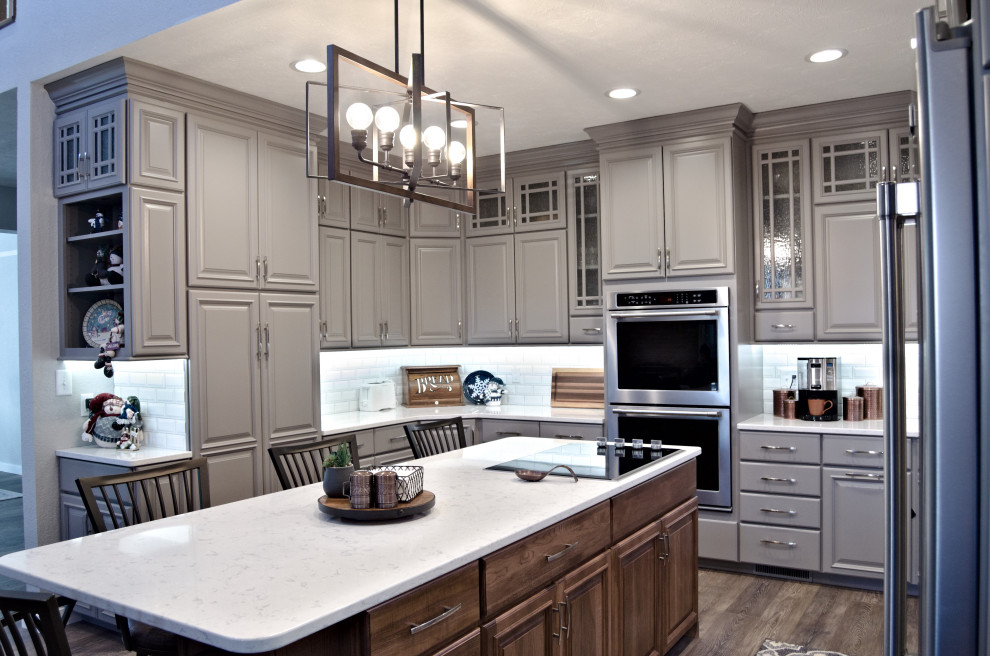 Eat-in kitchen - u-shaped brown floor eat-in kitchen idea with a double-bowl sink, raised-panel cabinets, gray cabinets, marble countertops, white backsplash, stainless steel appliances, an island and white countertops