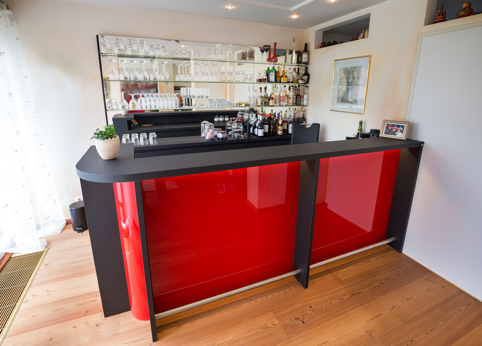 Inspiration for a contemporary home bar in Cologne with solid surface benchtops.