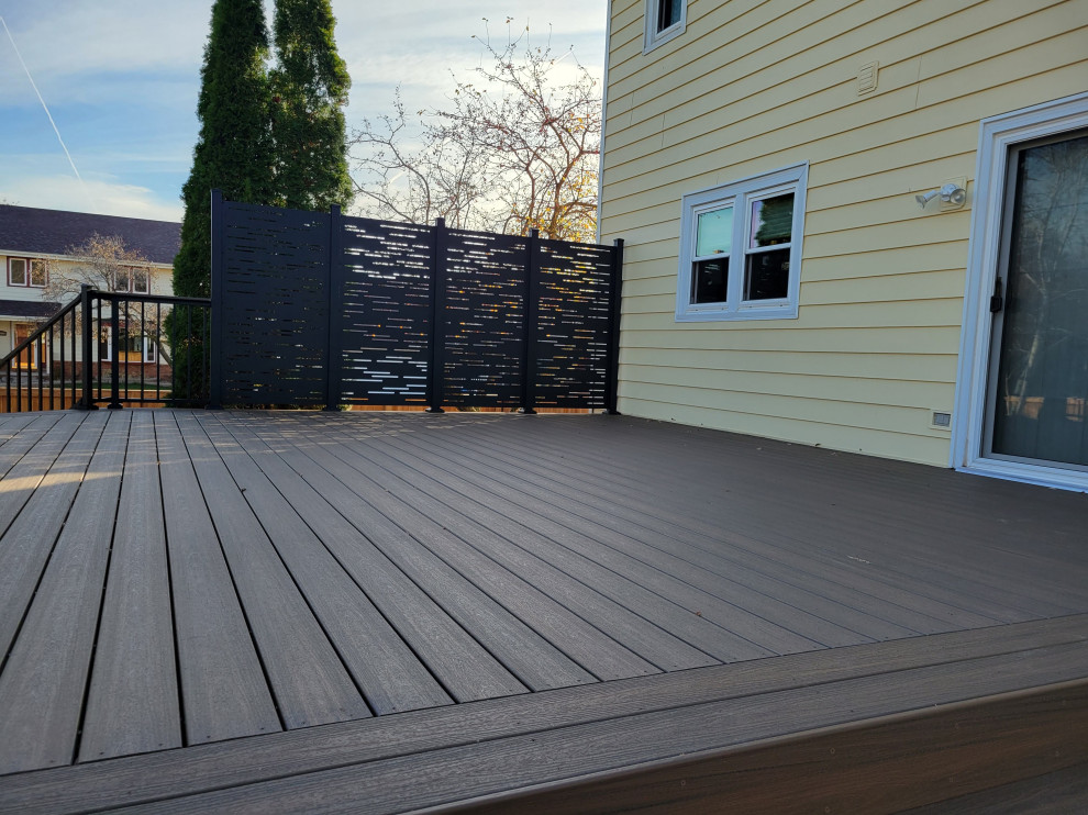 Deck - mid-sized backyard ground level privacy and metal railing deck idea with no cover