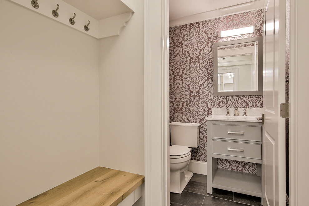 Inspiration for a small transitional powder room in Boston with grey cabinets, a two-piece toilet, multi-coloured walls, porcelain floors, an undermount sink, marble benchtops and beaded inset cabinets.