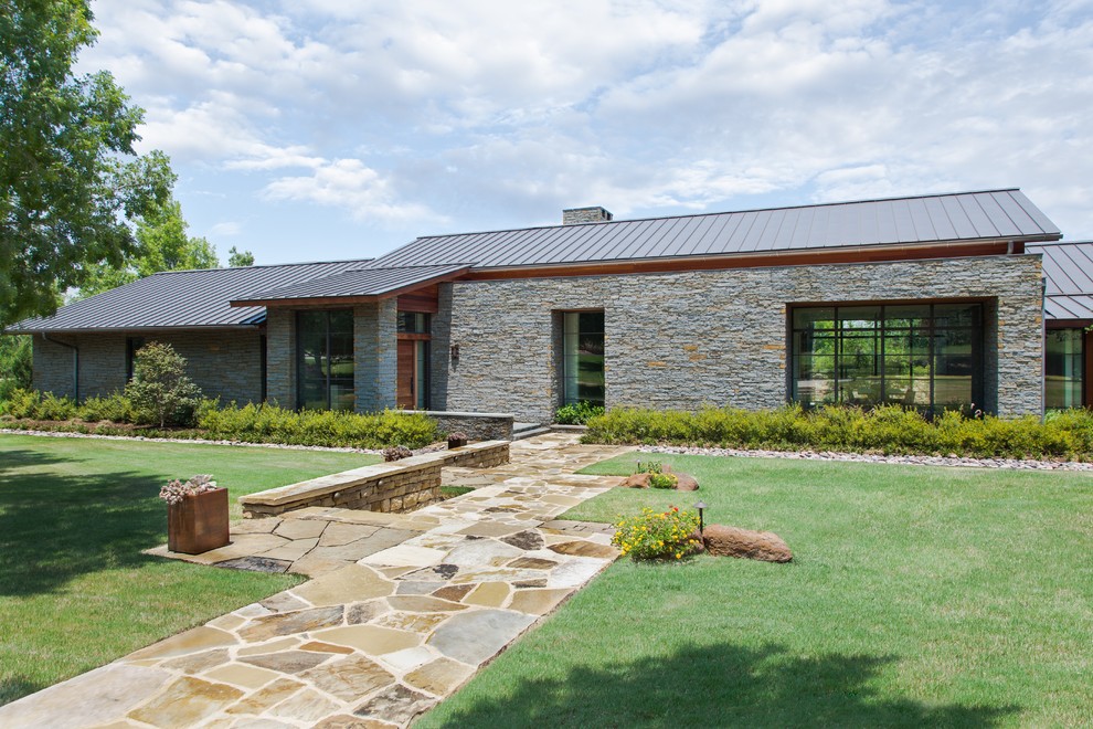 Design ideas for a large contemporary one-storey exterior in Dallas with stone veneer.