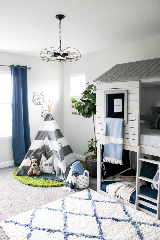 This is an example of a transitional kids' bedroom for boys in New York with white walls, carpet and grey floor.