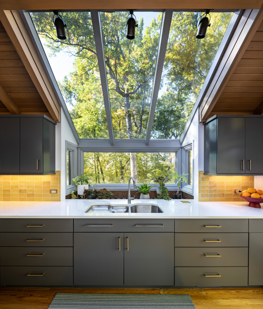 Bild på ett 50 tals grå grått kök och matrum, med gult stänkskydd och en köksö