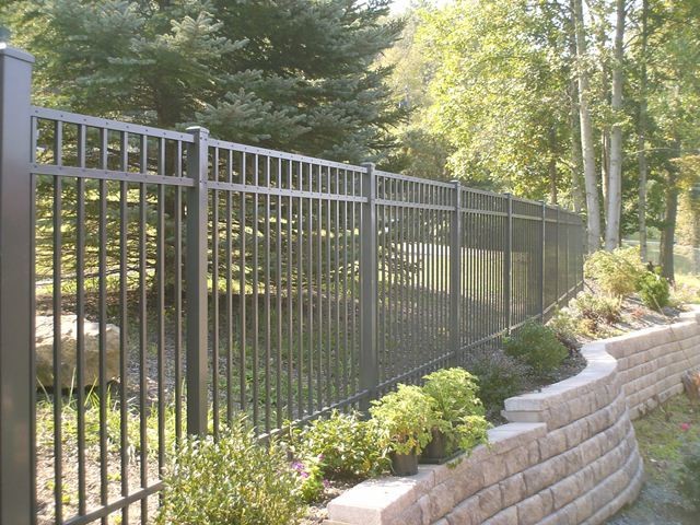 This is an example of a mid-sized traditional backyard partial sun garden in Other with a retaining wall and concrete pavers.