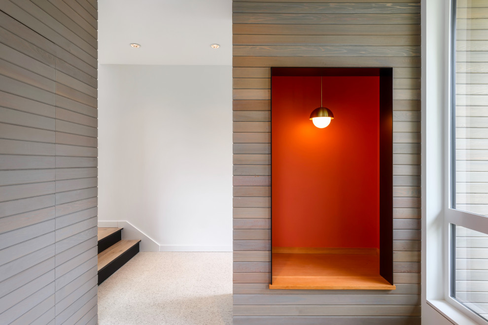 Inspiration for a mid-sized modern foyer in Seattle with white walls, terrazzo floors, a single front door, a glass front door, white floor and planked wall panelling.