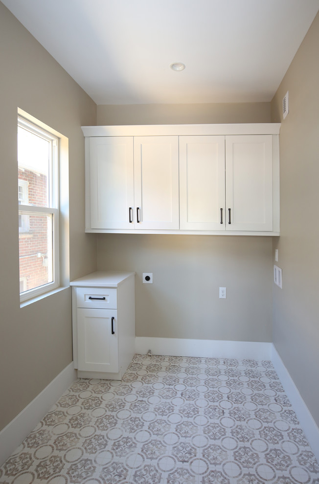This is an example of a mid-sized transitional single-wall dedicated laundry room in Denver with white cabinets, a side-by-side washer and dryer, white benchtop, recessed-panel cabinets, quartz benchtops, beige walls, ceramic floors and multi-coloured floor.