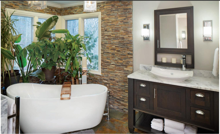Mid-sized transitional master bathroom in Indianapolis with furniture-like cabinets, brown cabinets, a freestanding tub, a double shower, a bidet, brown tile, slate, grey walls, slate floors, a vessel sink, marble benchtops, multi-coloured floor, a hinged shower door and white benchtops.