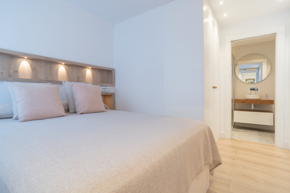 Diseño de dormitorio nórdico de tamaño medio con suelo de madera en tonos medios y suelo marrón