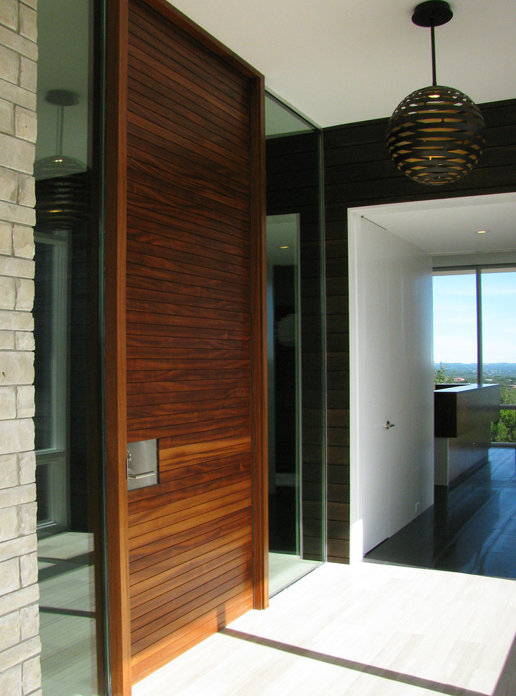 This is an example of a mid-sized modern front door in Austin with a pivot front door, a medium wood front door, white walls, beige floor and ceramic floors.