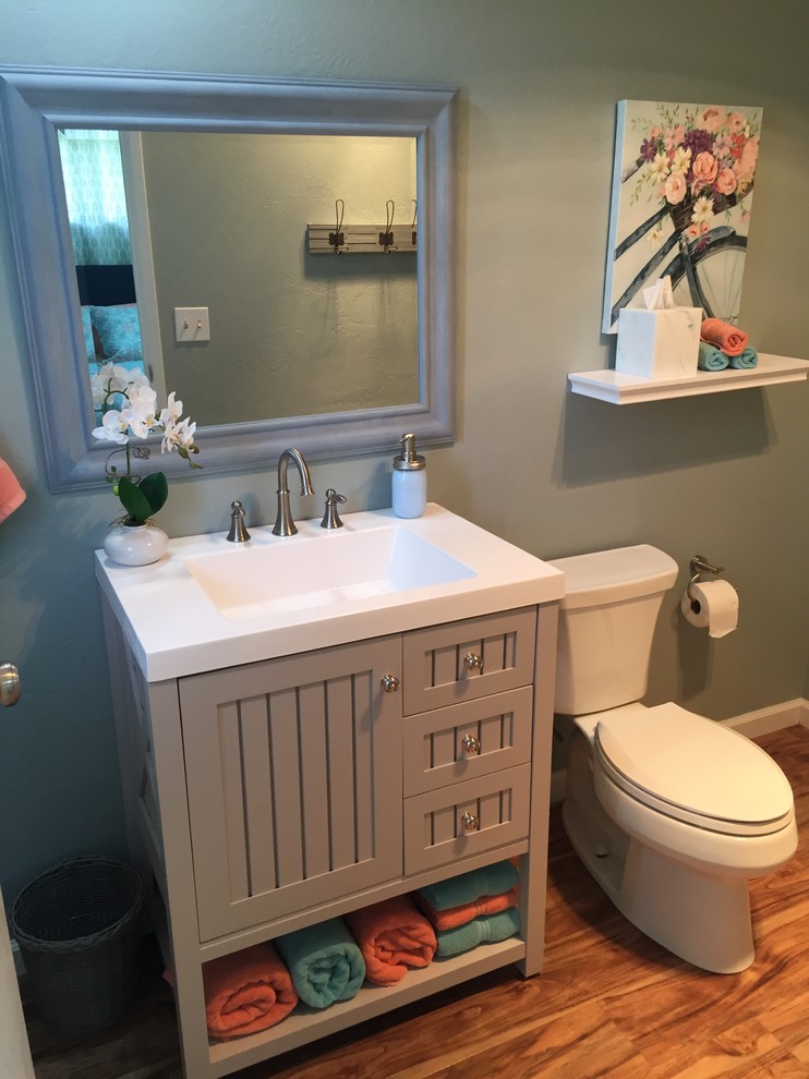 This is an example of a beach style bathroom in San Francisco with beaded inset cabinets, grey cabinets, an alcove shower, a two-piece toilet, blue walls, an integrated sink, engineered quartz benchtops, a sliding shower screen and white benchtops.