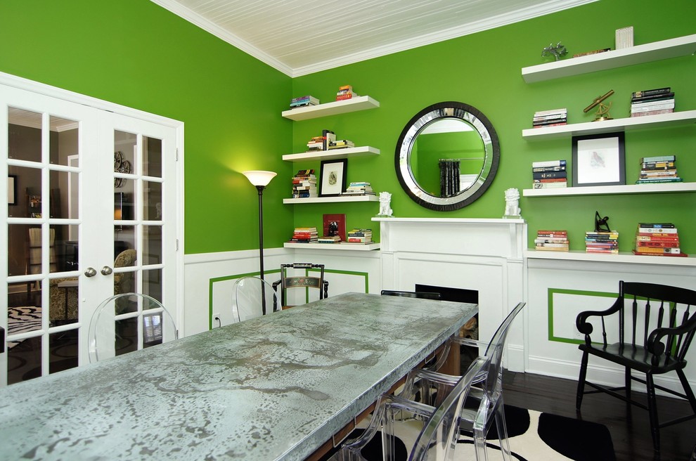 Inspiration for a small contemporary separate dining room in Raleigh with green walls, dark hardwood floors, a standard fireplace, a wood fireplace surround, brown floor and timber.
