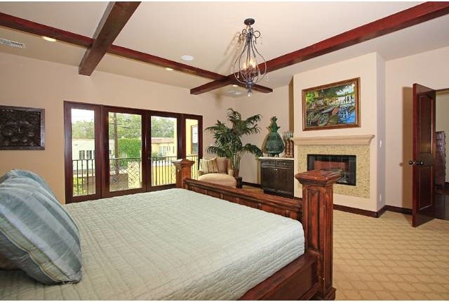This is an example of a large mediterranean master bedroom in Los Angeles with white walls, carpet and no fireplace.