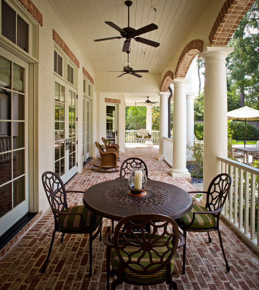 Inspiration for a mid-sized traditional backyard verandah in Houston with brick pavers and a roof extension.
