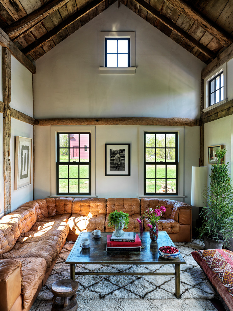 Idee per un soggiorno eclettico con pareti beige, travi a vista, soffitto a volta e soffitto in legno