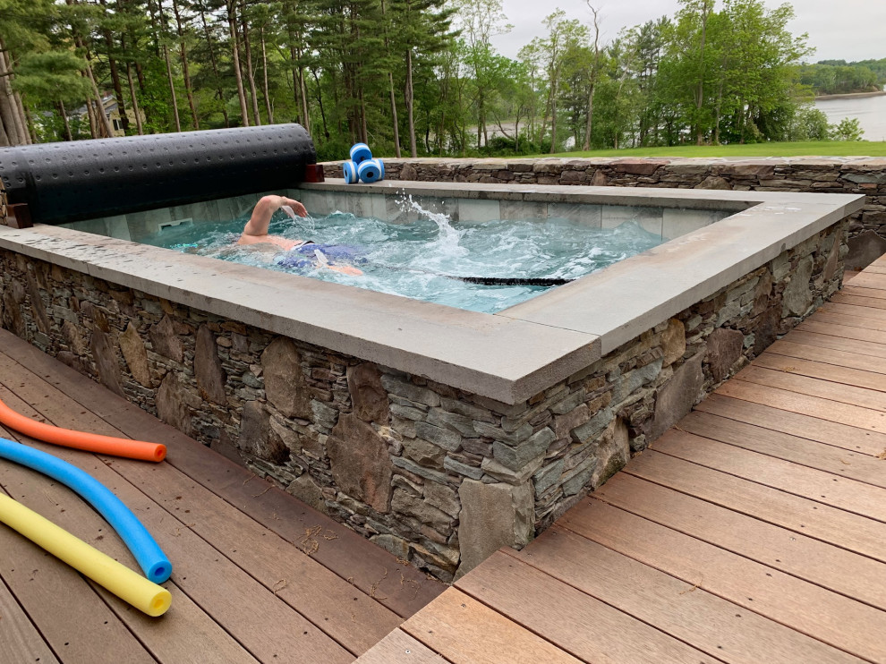 Small eclectic backyard rectangular aboveground pool in Portland Maine with a hot tub and decking.