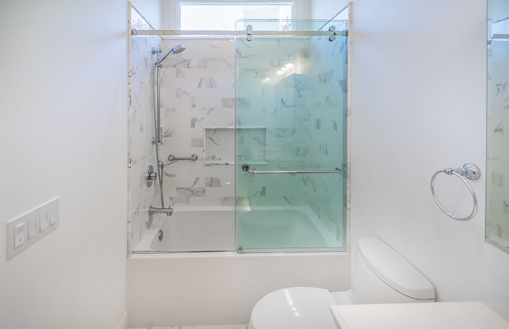 Photo of a mid-sized scandinavian master bathroom in Los Angeles with recessed-panel cabinets, white cabinets, an alcove tub, a corner shower, a one-piece toilet, white tile, ceramic tile, white walls, marble floors, an undermount sink, engineered quartz benchtops, multi-coloured floor, a sliding shower screen and grey benchtops.