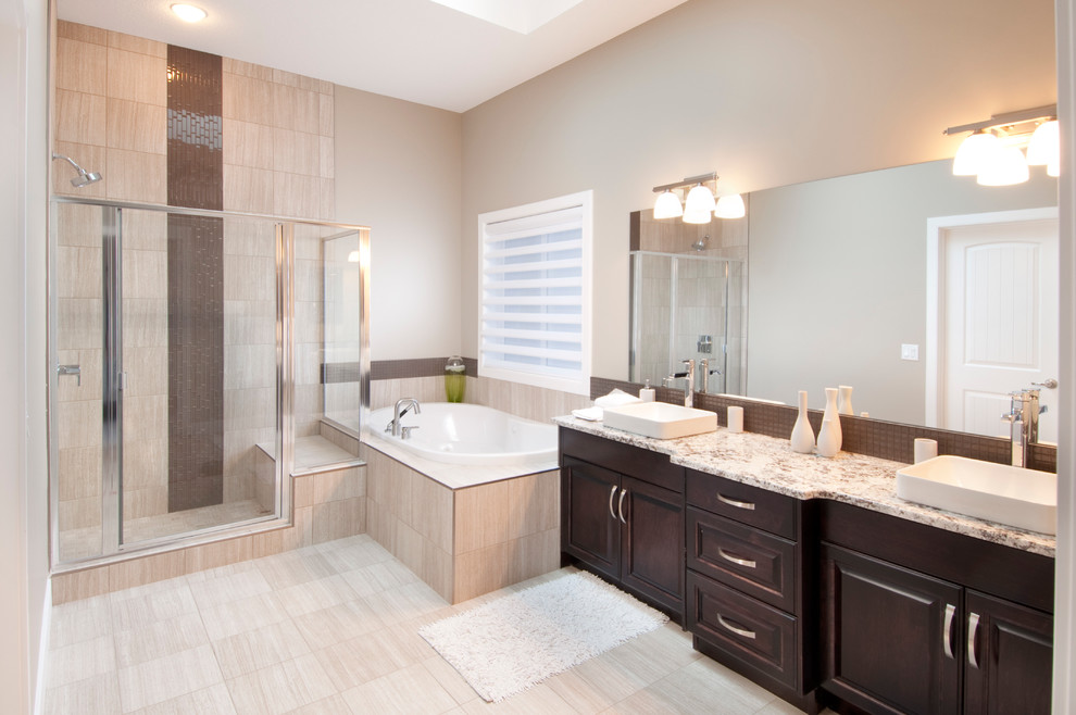 Design ideas for a large modern master bathroom in Calgary with a vessel sink, raised-panel cabinets, dark wood cabinets, granite benchtops, an alcove tub, beige tile, cement tile, beige walls, ceramic floors and a corner shower.