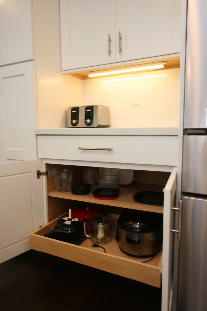 Large transitional u-shaped dark wood floor eat-in kitchen photo in Orange County with a farmhouse sink, shaker cabinets, white cabinets, quartz countertops, white backsplash, ceramic backsplash, stainless steel appliances and an island