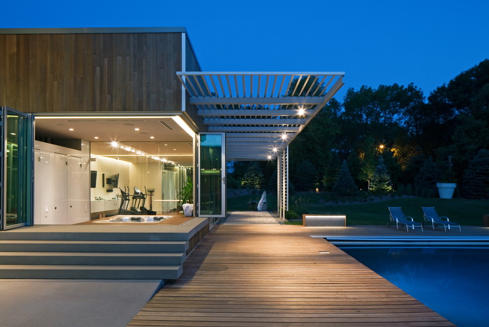 This is an example of a contemporary deck in Omaha with a pergola.