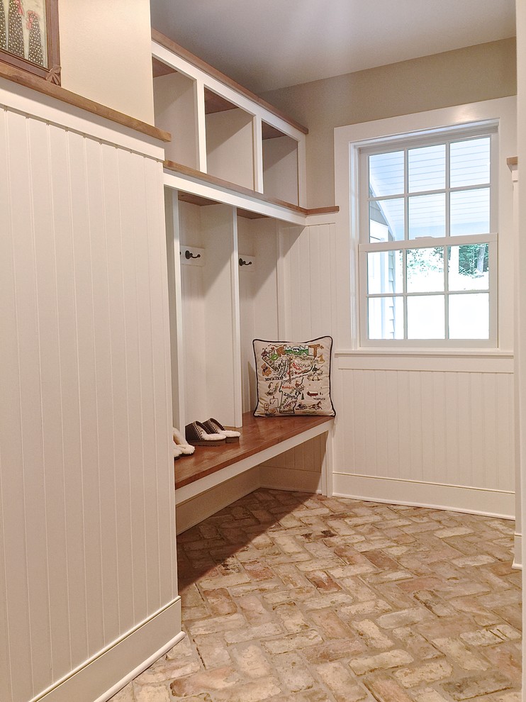 Photo of a mid-sized transitional mudroom in Burlington with beige walls, brick floors, a single front door and a dark wood front door.