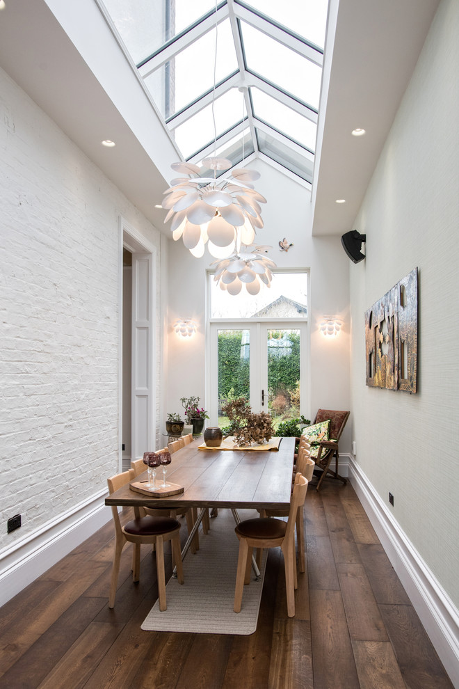 Inspiration for a transitional separate dining room in Manchester with white walls, dark hardwood floors and brown floor.