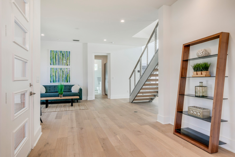 Photo of a modern entryway in Tampa with light hardwood floors and beige floor.