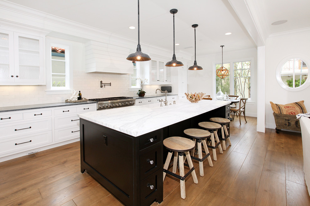 Inspiration for a beach style eat-in kitchen in Orange County with white cabinets, stainless steel appliances and shaker cabinets.