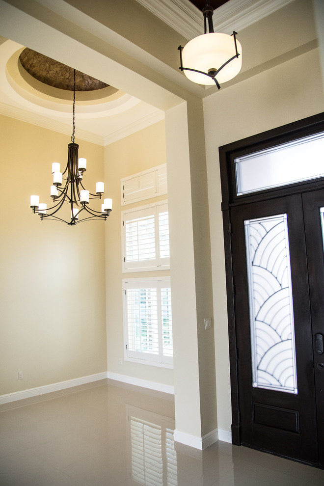 Example of a mid-sized transitional porcelain tile foyer design in Austin with beige walls and a dark wood front door