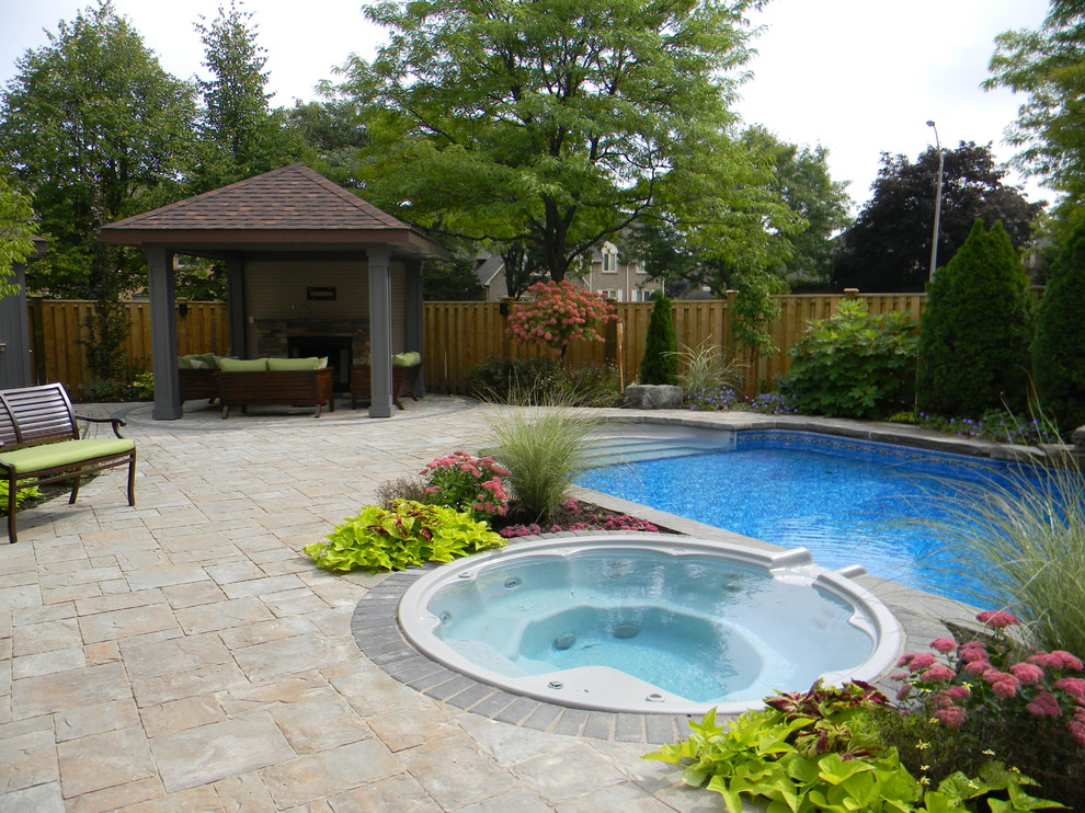 Inspiration for a mid-sized transitional backyard concrete paver and rectangular hot tub remodel in Toronto