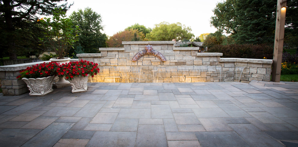 Design ideas for a transitional backyard stone water fountain landscape in Omaha.
