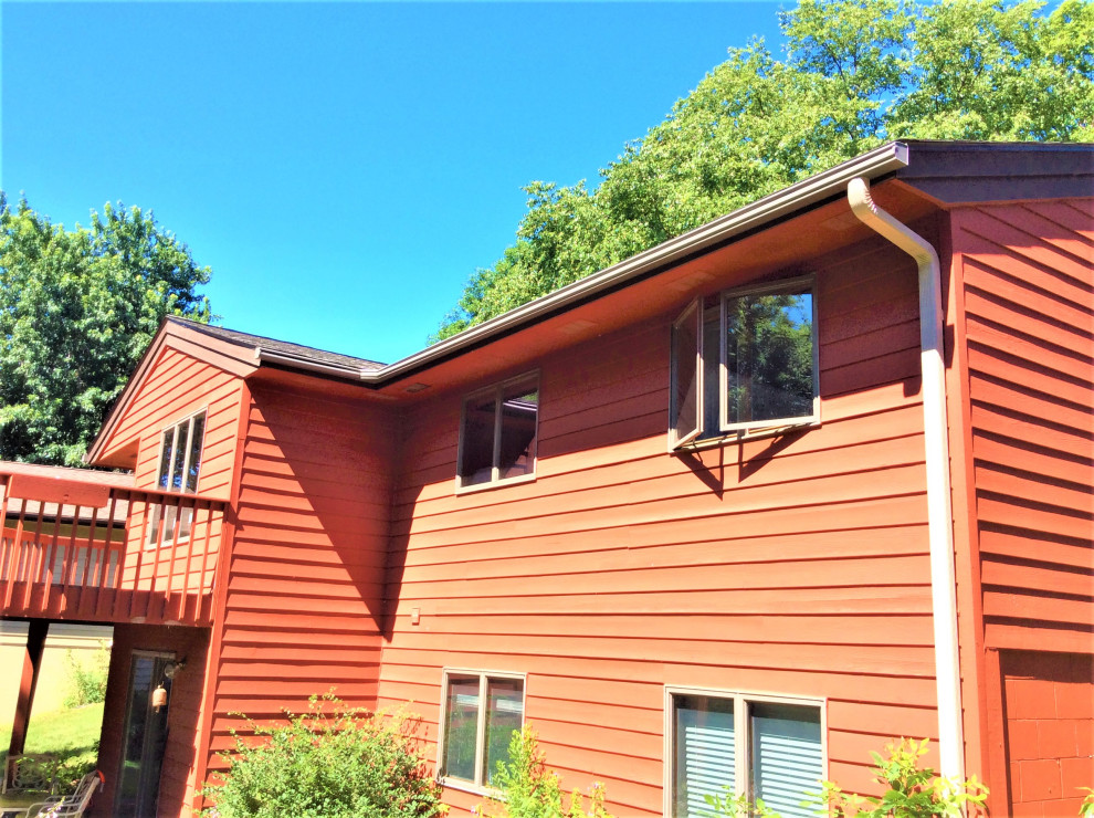 Cette photo montre une façade de maison rouge rétro de taille moyenne et à niveaux décalés avec un toit marron.