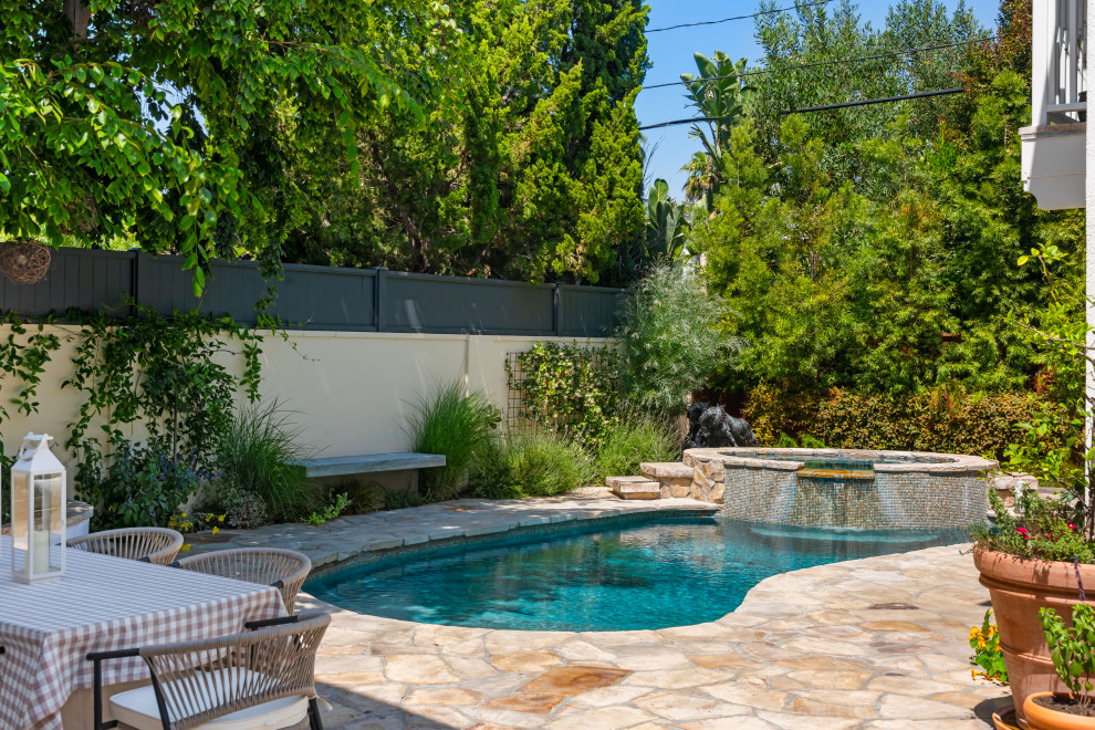 Hot tub - mediterranean stone and kidney-shaped hot tub idea in Los Angeles