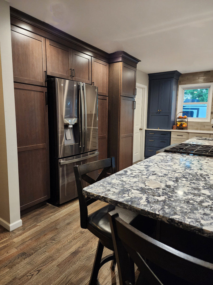 Inspiration for a large farmhouse l-shaped medium tone wood floor and gray floor eat-in kitchen remodel with an undermount sink, shaker cabinets, subway tile backsplash, stainless steel appliances, an island and multicolored countertops