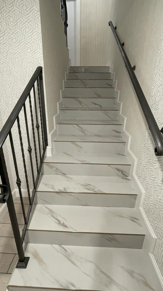 Cette image montre un escalier carrelé droit design de taille moyenne avec des contremarches carrelées, un garde-corps en métal et du papier peint.