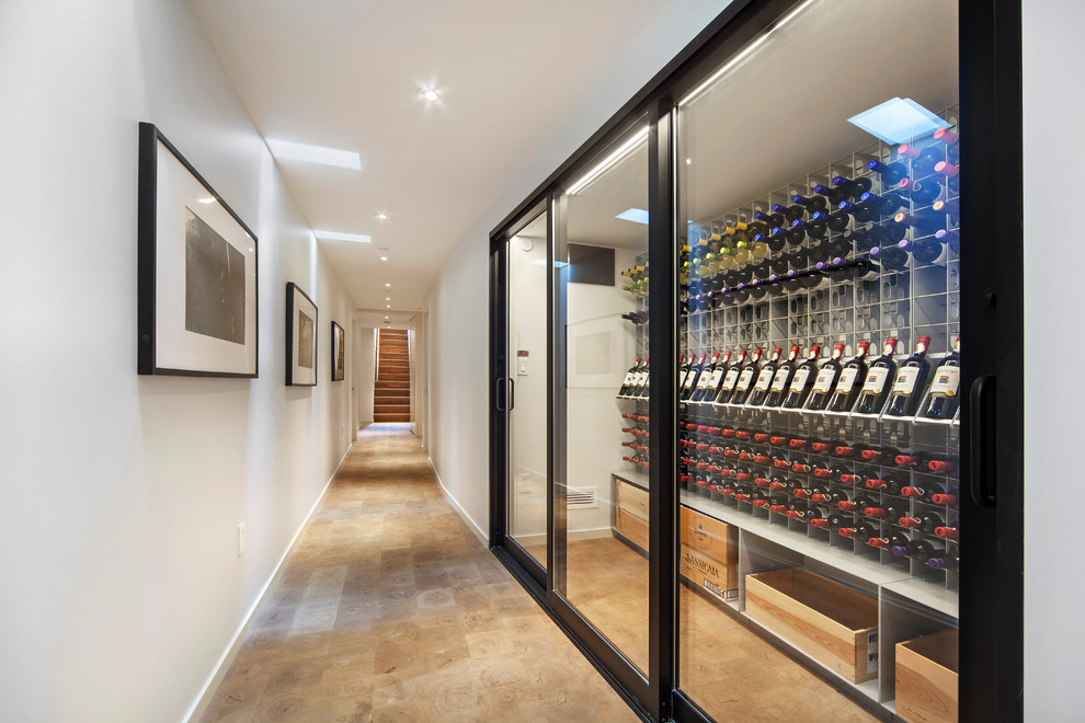 Contemporary wine cellar in New York with brown floor and display racks.