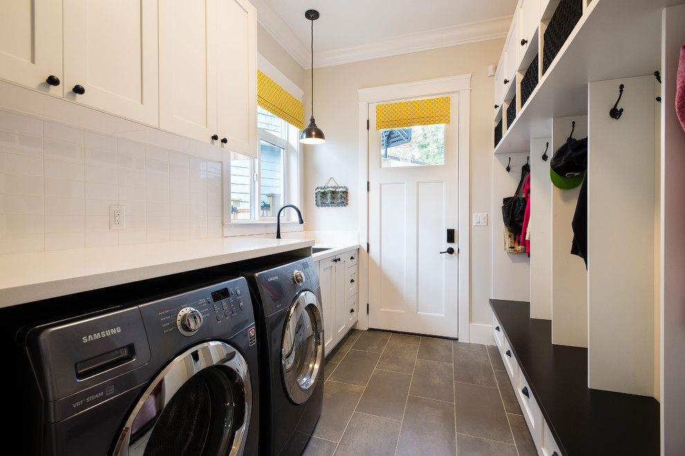 Inspiration for a mid-sized traditional galley utility room in Vancouver with an undermount sink, shaker cabinets, white cabinets, quartz benchtops, grey walls, porcelain floors and a side-by-side washer and dryer.