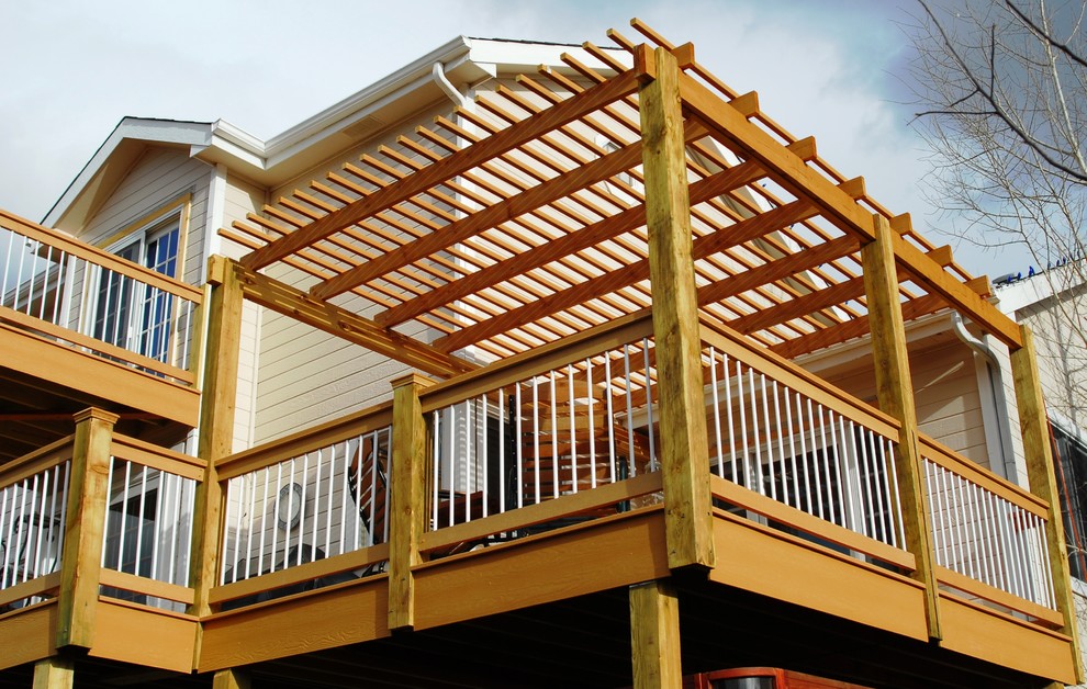 Inspiration for a large rustic backyard deck remodel in Denver with a pergola