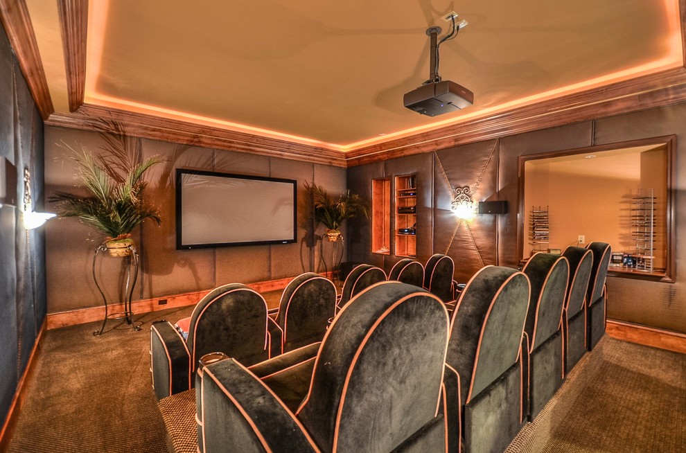 This is an example of a traditional enclosed home theatre in Charlotte with brown walls, carpet, a projector screen and brown floor.