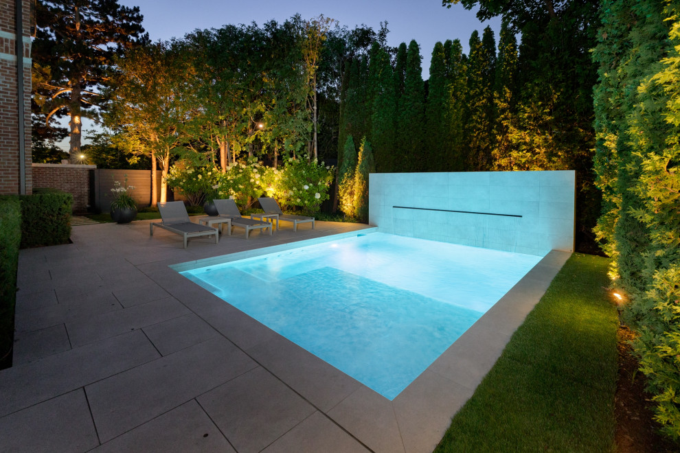 Photo of a small traditional side rectangular swimming pool in Toronto with with pool landscaping and natural stone paving.