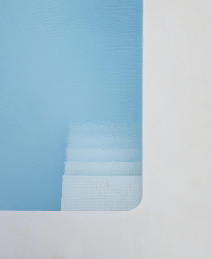 Foto di una piscina minimalista personalizzata di medie dimensioni e dietro casa con pavimentazioni in cemento