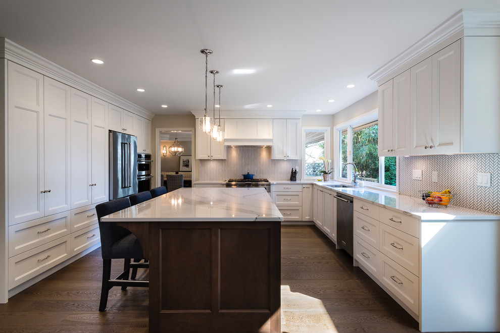 Inspiration for a large transitional u-shaped medium tone wood floor and brown floor eat-in kitchen remodel in Vancouver with an undermount sink, recessed-panel cabinets, white cabinets, quartz countertops, white backsplash, mosaic tile backsplash, stainless steel appliances and an island