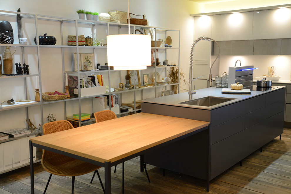 This is an example of an industrial single-wall kitchen in Osaka with a single-bowl sink, blue cabinets, medium hardwood floors and with island.